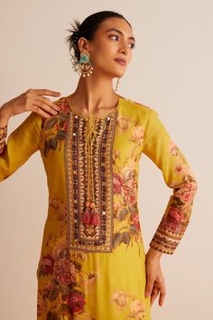 Yellow straight kurta with floral print, highlighted with mirror work and tassels. Paired with a churidar and dupatta.
Components: 3
Pattern: Print
Type Of Work: Floral
Neckline: Round Neck
Sleeve Type: Full Sleeves
Fabric: Cotton Silk
Color: Yellow
Other Details: 
Model height:  5 ft 9 inches, wearing size S
Length:
Kurta Length - 46 inches
Churidar Length - 55 inches
Floral print dupatta with tassels
Occasion: Puja - Aza Fashions Kurta Set For Women, Kurta Neck Design, Straight Kurta, Mirror Work, Churidar, Kurta Set, Full Sleeves, Set For Women, Cotton Silk