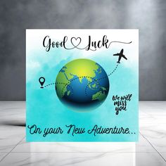 a greeting card with an airplane flying over the earth and words good luck on your new adventure