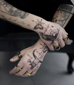 two people holding hands with tattoos on them