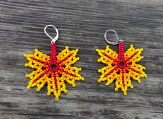 two pairs of beaded earrings with red, yellow and orange beads hanging from hooks