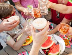 a group of people sitting around a table with food and drinks