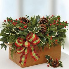 a wooden box filled with holly and pine cones