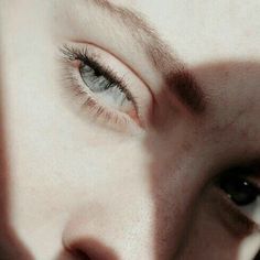 a close up of a person's face with an orange eye