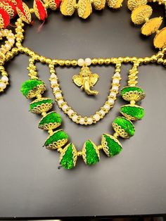 an elaborate necklace with green leaves and pearls