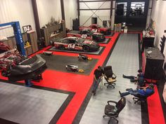 the garage is full of racing cars and mechanics