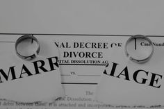 two marriage rings sitting on top of a marriage paper with the word marriage in black and white