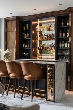 an elegant bar with stools and bottles on the shelves, along with several wine glasses