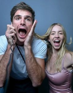 two people with their mouths open and one person holding his hand up to the camera