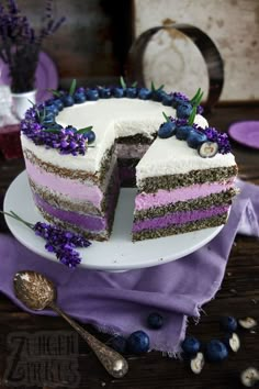 there is a cake that has been cut in half and purple flowers are on the plate