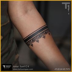 a woman's arm with a tattoo on it and a black band around the wrist