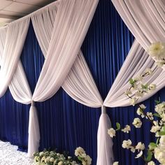 a blue and white wedding backdrop with flowers