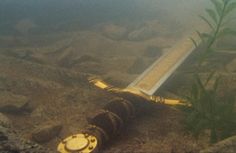 an underwater view of a metal object in the water