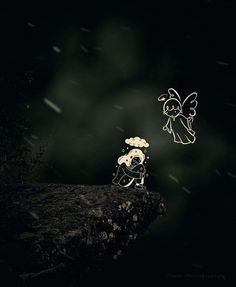 two little angels sitting on top of a rock in the dark