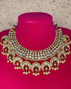 Celebrate your special occasion with this unique gold necklace that is sure to grab everyone's attention. The necklace comes with matching earrings and is in a gold finish with kundan work to accentuate the look. The pearls add an elegant touch to the set and it can also be worn alone for a statement look. Festive Round Kundan Necklace Gold Plated, Festive Round Gold-plated Kundan Necklace, Gold Plated Chandbali Kundan Necklace For Diwali, Diwali Gold-plated Chandbali Kundan Necklace, Diwali Gold Plated Chandbali Kundan Necklace, Gold Plated Chandbali Necklaces For Celebration, Gold Plated Chandbali Necklace For Celebrations, Gold Plated Round Kundan Necklace Bollywood Style, Hand Set Gold Plated Kundan Necklace For Celebration