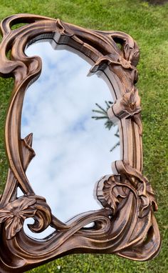 a mirror sitting on top of a green grass covered field