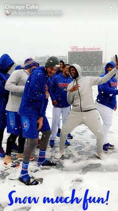 a group of baseball players standing in the snow with their arms around each other and smiling