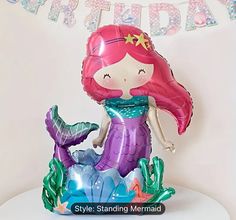 a little mermaid balloon sitting on top of a table