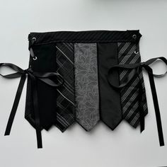 four ties are tied together with black satin ribbons and bow tie clips on the belt