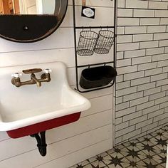 a white sink sitting under a mirror next to a wall mounted soap dispenser