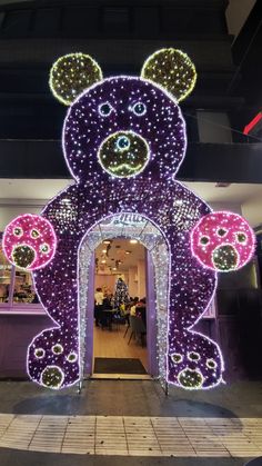 a large teddy bear decorated with lights and decorations