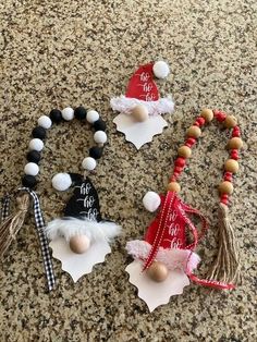 three christmas ornaments are laying on the counter top, one is wearing a santa hat