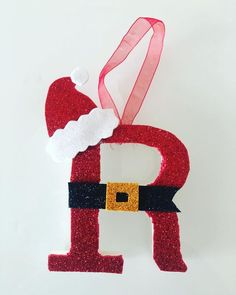 an ornament made to look like santa claus's letter p is hanging on a wall