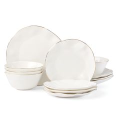 white dishes with gold rims are stacked on top of each other in front of a white background