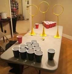 a table with cups on it that has some sort of pong game in front of it