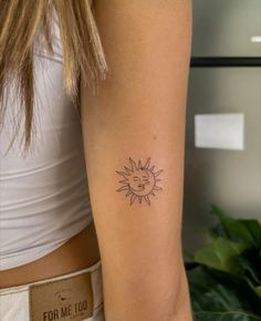 a woman with a sun tattoo on her arm