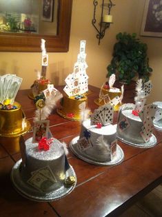 a wooden table topped with lots of cakes covered in cards and money sitting on top of it