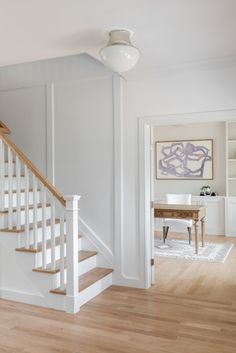 a white staircase leading up to a dining room table