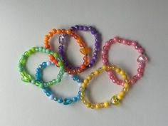 rainbow set of 6 small handmade beaded bracelets for kids, toddlers with a heart bead on each Playful Heart-shaped Letter Beads Bracelet, Colorful Adjustable Round Bead Jewelry, Cute Everyday Beaded Bracelets, Handmade Flexible Friendship Bracelets As Gift, Handmade Friendship Bracelets As Gift, Rainbow Spacer Beads Jewelry As A Gift, Adjustable Rainbow Heart Beads Jewelry, Adjustable Rainbow Beaded Bracelets With Heart Beads, Handmade Adjustable Playful Jewelry