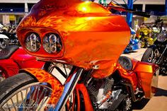 an orange motorcycle with flames painted on it's headlight and front fenders