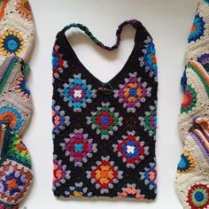 three crocheted purses, one in multicolored yarn