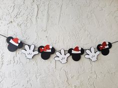 a mickey mouse party banner hanging on a string with red and white felt hats attached to it