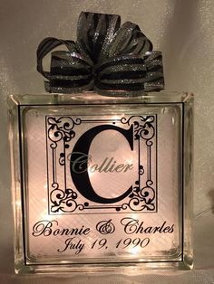 an acrylic block with the letter c on it and a ribbon tied around it