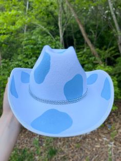 Blue Cowprint with Rhinestone Band Cowboy Hat. This cowboy hat is the perfect addition to your party, events, and even cute photos! This is an adult-sized, polyester cowboy hat hand-painted with a double rhinestone band. The cowprint is only on the top of the hat. The bottom of the hat is white. The hat circumference is 23 inches. Keep in mind that this is not a fitted cowboy hat, one size fits most but it ranges on the larger size. We hope you will love this stunning hat as much as we do! You c Painted Cowboy Hats Ideas, Cowboy Hat Ideas, Diy Cowboy Hats, Blue Cowgirl Hat, Painted Cowboy Hats, Blue Cowboy Hat, Sombrero Cowboy, Horror Clothes, Cowboy Hut