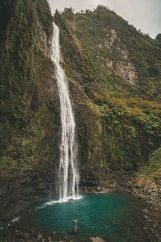 a person standing in front of a waterfall