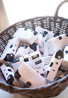 a wicker basket filled with small white and black electronic gadgets on top of a table