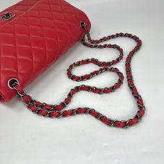 Chanel Classic Jumbo Double Flap Bag From 2014 with Gunmetal Hardware,Chain/Leather Straps,Interlocking CC Turn Lock Closure and Multiple Interior Compartments. Auth # 19986686 with Dustbag Designer = Chanel Color = Red Material = Lambskin Leather Condition = Very Good Height = 7.5 Width = 12 Depth = 3 1/2" Class = Premier Location: Chicago Item Number: 18321-1 Item ID: 255679 Category: Shoulder Bag Luxury Red Shoulder Bag With Palladium Hardware, Classic Red Bag With Chain Strap, Luxury Red Bag With Chain Detail, Classic Red Shoulder Bag With Chain Strap, Red Evening Bag With Chain, Chanel Classic Jumbo, Gunmetal Hardware, Leather Chain, Flap Bag