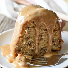 a piece of cake on a plate with a fork and caramel drizzle