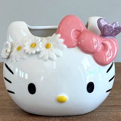 a ceramic hello kitty planter sitting on top of a wooden table