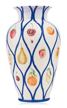 a blue and white vase with fruit painted on the side, in front of a white background