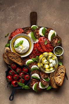 a platter filled with bread, tomatoes and other toppings on top of it