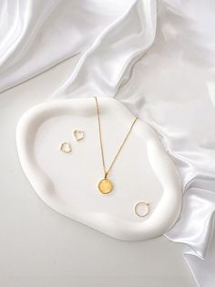 the necklace and earring set is laying on a white plate