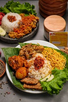 two plates filled with food on top of a table next to other foods and vegetables