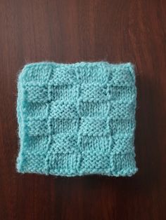 a knitted dishcloth sitting on top of a wooden table