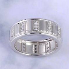 Bold and unique, this wedding band will be a good choice for people who are looking for a men's wedding band. Crafted in sterling silver, sculptured with vertical grooves on the shank, the band will show a really unique look on your hand. Three round stones are set in every vertical groove to add sparkle to the band. Just take this handsome design. It won't disappoint you!Carat Weight: 0.666 ctStone Size: 1.3 mmStone Type: Jeulia® StoneNumber of Stones: 36 Stone Color: Diamond WhiteStone Shape: RoundWeight: 5.15 gWidth: 7.52 mmThickness: 2.12 mmMaterial: 925 SilverPlating Color: Silver Classic Silver Bands With Vvs Clarity, Classic Silver Band With Vvs Clarity, Luxury Silver Rings With Decorative Band, Formal Silver Sterling Silver Eternity Band, Formal Sterling Silver Eternity Band, Silver Sterling Eternity Band For Formal Occasions, Classic Sterling Silver Eternity Band In Silver, Modern Silver Eternity Band For Formal Occasions, Luxury Silver Promise Ring