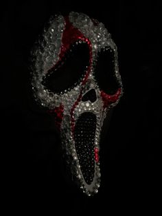 a pair of red and white scissors in the shape of a skull on a black background