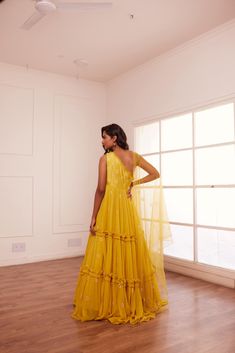 Yellow one shoulder embroidered yoke with layered georgette ghera paired up with yellow net dupatta. No. of pieces in a set: 2 Color: Yellow Fabric Composition: Opada silk, net, georgette Lining Material: Shantoon Closure used: Side zip in anarkali Dress Length : Full Silhouette: Anarkali Neck type : One shoulder Sleeve Length: Sleeveless Waistline: High waist Prints/ Pattterns : Plain Delivery Time: 20-25 days Yellow Anarkali Gown With Sheer Dupatta, Yellow Anarkali Dress With Sheer Dupatta, Yellow Floor-length Dress With Sheer Dupatta, Yellow Georgette Dress With Traditional Drape, Yellow Gown With Sheer Dupatta, Yellow Organza Dress For Navratri, Yellow Dress With Sheer Dupatta For Diwali, Yellow Georgette Gown With Cutdana, Semi-stitched Yellow Gown With Sheer Dupatta